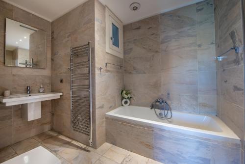 a bathroom with a tub and a sink at VICTOR HUGO - Modern and sunny, terrace, 2 baths in Nice