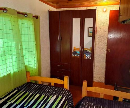 a room with two beds and a cabinet and a mirror at El remanso de Jaure in Jaureguiberry