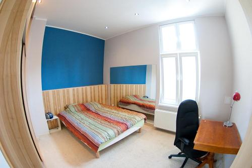 a bedroom with a bed and a desk and a window at Classic Apartment with Private Sauna in Old Town in Gdańsk