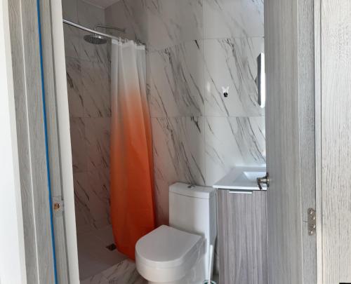 - une salle de bains avec un rideau de douche orange à côté des toilettes dans l'établissement Lovely flat with pool in city center, à Panama City
