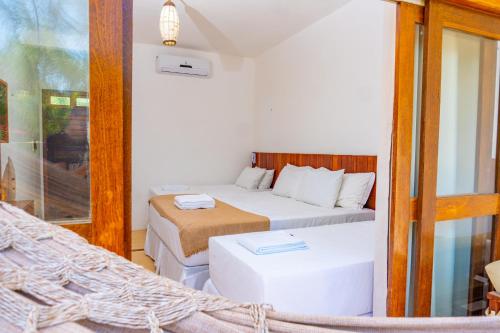 a small bedroom with two beds at Pousada Coco Cabana in Camocim