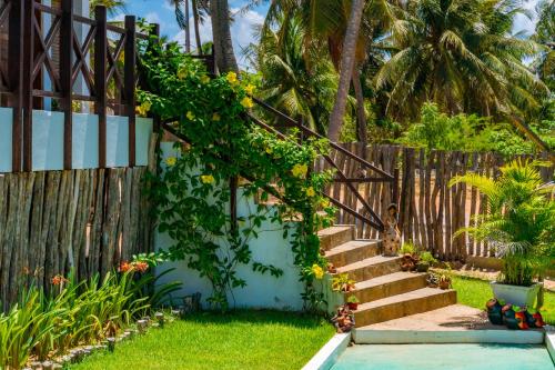a garden with a wooden fence and stairs at Pousada Coco Cabana in Camocim