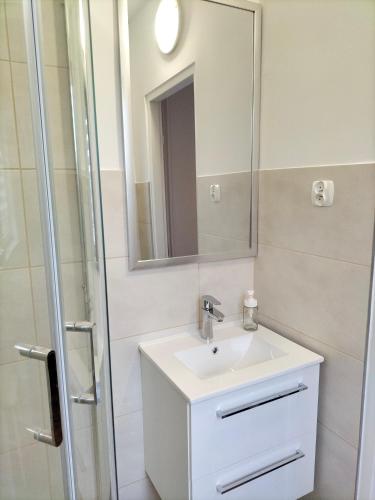 a bathroom with a sink and a mirror at Pokoje i apartamenty Mak in Łeba
