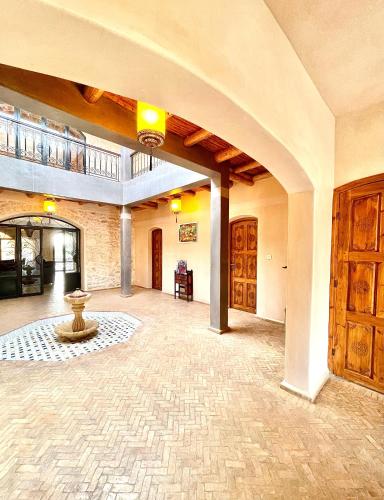 Habitación grande con suelo de piedra y arco. en Villa Kyanite, en Essaouira