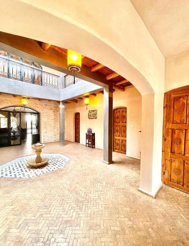 Una gran habitación con suelo de piedra y un arco. en Villa à Essaouira, en Essaouira