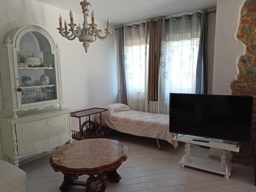 een woonkamer met een flatscreen-tv en een tafel bij Villa Bersani in CastellʼArquato