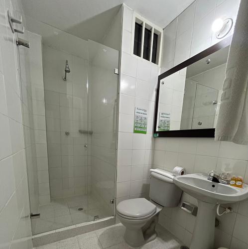 a bathroom with a shower and a toilet and a sink at Hotel Tupinamba Neiva in Neiva