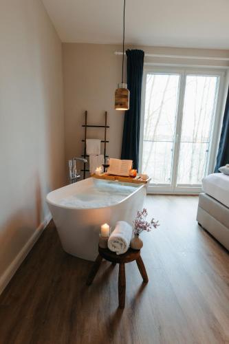 a bathroom with a white tub and a large window at Tien Stuuv in Ratzeburg