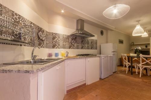 a kitchen with a sink and a refrigerator at Villa con grande giardino ad 800 mt dal mare in Capitana