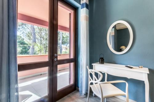 a room with a door and a mirror and a chair at Villa con grande giardino ad 800 mt dal mare in Capitana