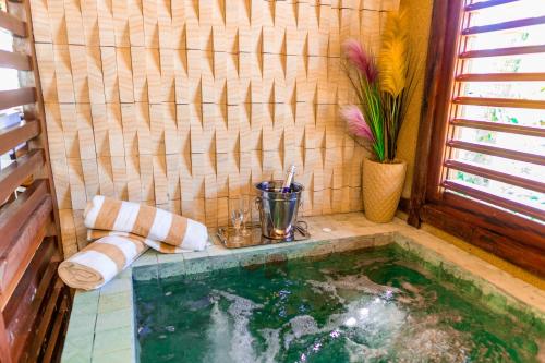a bathroom with a pool of water in a room at Pousada Coco Cabana in Camocim