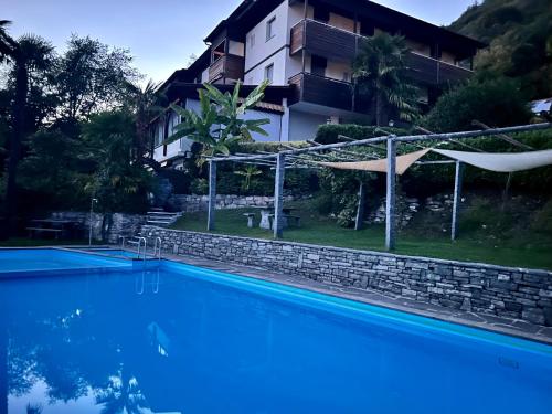 - une vue sur la piscine en face d'un bâtiment dans l'établissement Wohnung mit Aussicht auf Lago Maggiore & Pool, à Contra