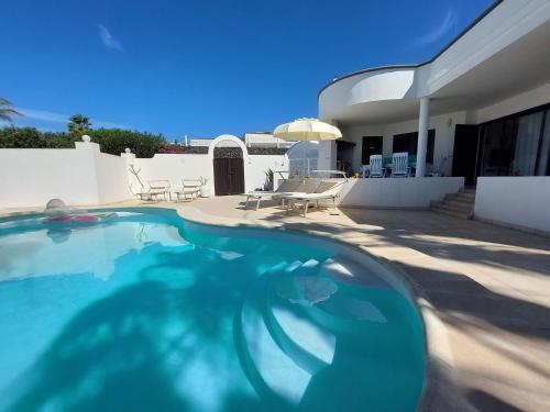 a swimming pool in front of a house at Sol y Luna Room & Suite Lanzarote Holidays - Heated pool! in Playa Blanca