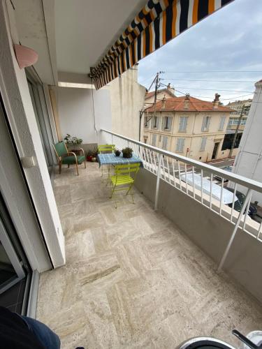 un balcon avec une table et des chaises sur un immeuble dans l'établissement Grand appartement de style avec parking - Cannes, à Cannes