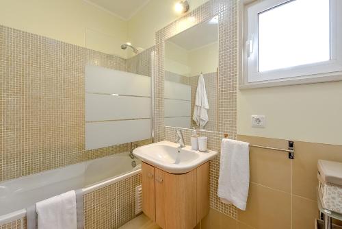 a bathroom with a sink and a tub and a mirror at Penthouse Cassia in Cabanas de Tavira