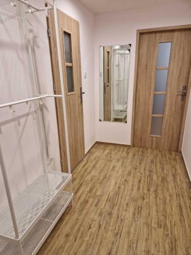 pusty pokój z drzwiami i drewnianą podłogą w obiekcie Apartament w Centrum w mieście Prudnik