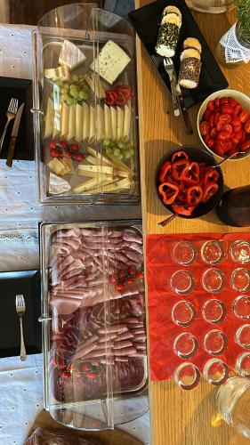 a wooden table topped with a container of food and vegetables at Kreiers Alp in Hohenems