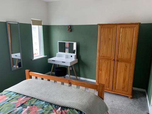 ein Schlafzimmer mit einem Bett, einem Waschbecken und einem Spiegel in der Unterkunft La Brisa-fully refurbished, perfect local in Portrush