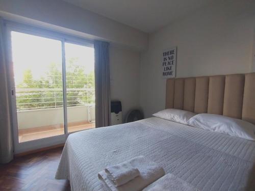 a bedroom with a bed with two towels on it at Depto San Lorenzo in Rosario