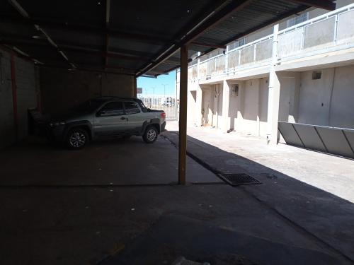 un coche aparcado en un aparcamiento al lado de un edificio en Deptos La Punta en La Punta