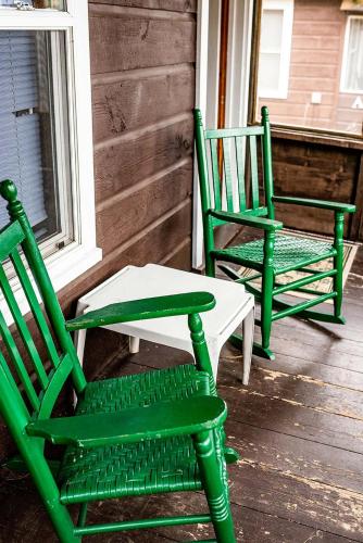two green rocking chairs sitting on a porch at The Long View Lodge in Long Lake