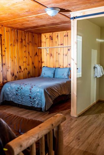 a bedroom with a bed in a wooden wall at The Long View Lodge in Long Lake