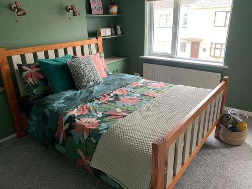 - une chambre avec un lit en bois et une couette à fleurs dans l'établissement La Brisa-fully refurbished, perfect local, à Portrush