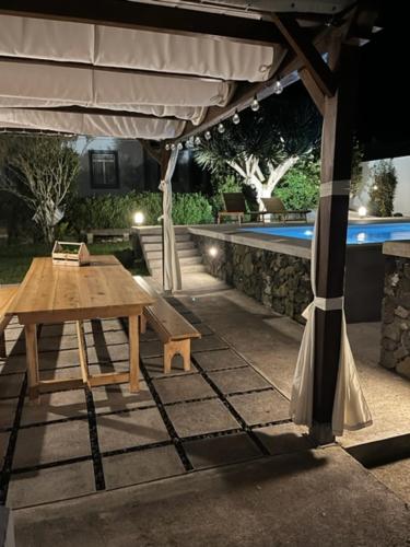 a picnic table under an umbrella next to a pool at Casa Às Seis in Angra do Heroísmo