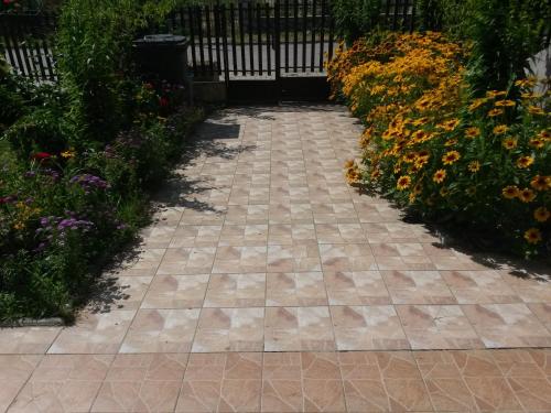 a walkway in a garden with flowers at Marko Apartments in Struga