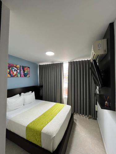 a hotel room with a bed and a television at Hotel Tupinamba Neiva in Neiva