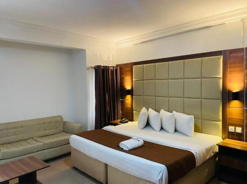 イケジャにあるPresken Residenceのベッドとソファ付きのホテルルーム