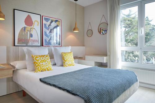 扎魯亞斯的住宿－ATeRIAN GAZTELU，一间卧室配有一张大床,提供黄色和蓝色的枕头