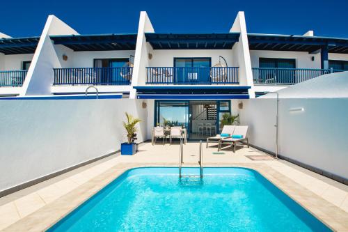 una villa con piscina e una casa di FRONTLINE VILLA 26, Modern Coastal Design with Amazing Views a Puerto Calero