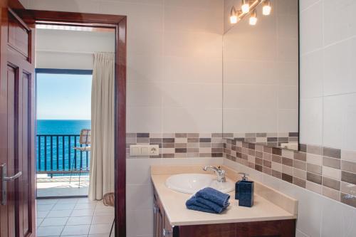a bathroom with a sink and a view of the ocean at FRONTLINE VILLA 26, Modern Coastal Design with Amazing Views in Puerto Calero