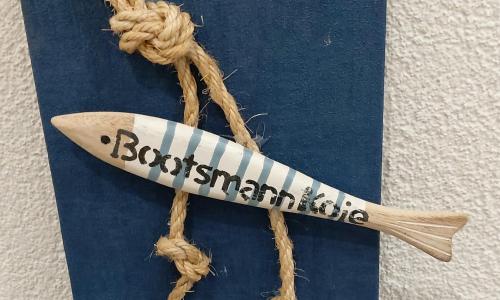 a wooden spoon with the word bosham on it next to a rope at Ferienhaus Pomerania Bootsmann Koje kleine Auszeit bei Rügen in Sundhagen