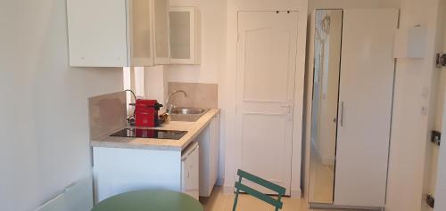 - une petite cuisine blanche avec un évier et un comptoir dans l'établissement Le Suquet, à Cannes