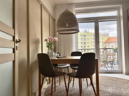 a dining room with a table and chairs and a window at Sweet Home by Zoom Apartments in Nivy
