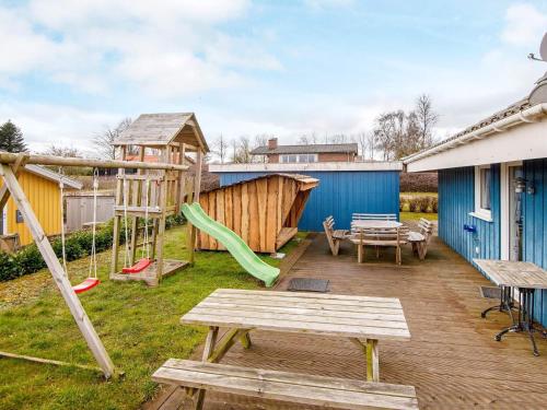 a backyard with a playground with a slide and a table at 8 person holiday home in Hejls in Hejls