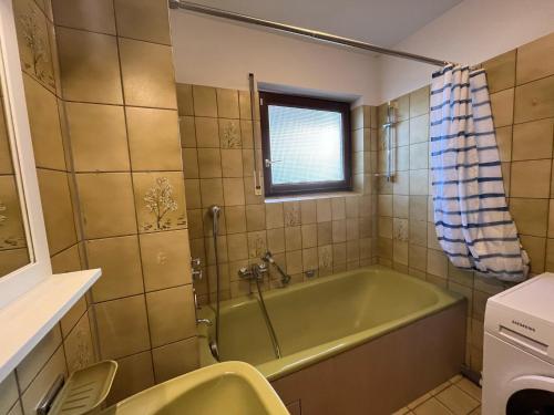 a bathroom with a green tub and a window at 70m2 Appartment with 2 Bedrooms, Balcony and Garage in Neckarsulm