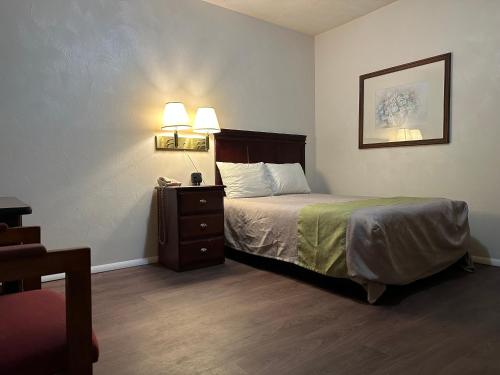 sypialnia z łóżkiem i 2 lampkami na ścianie w obiekcie Heritage Inn w mieście Uniontown