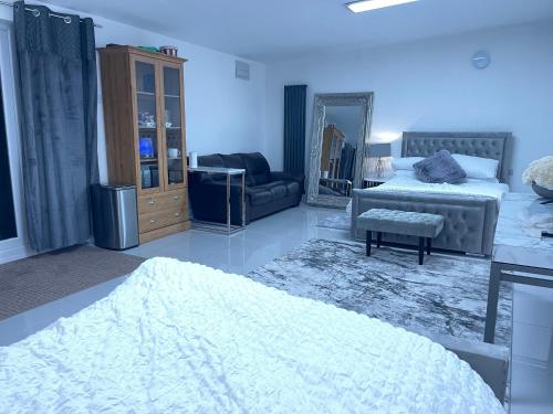 a bedroom with a bed and a couch and a mirror at CF14 in Cardiff