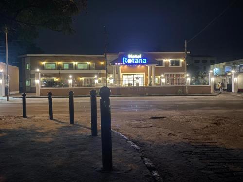 a restaurant with a neon sign in front of a building at Hôtel rotana in Brazzaville