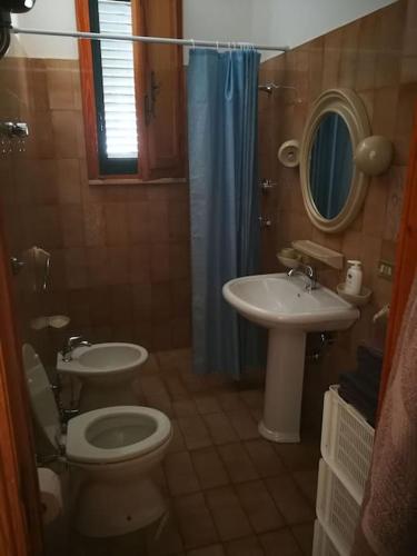 ein Badezimmer mit einem WC, einem Waschbecken und einem Spiegel in der Unterkunft Appartamento vista mare a 10 minuti da Castro Marina in Andrano