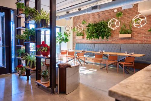 a restaurant with tables and chairs and potted plants at The Maj Hotel in Philadelphia