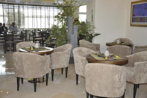 a restaurant with tables and chairs and people in the background at Addissinia Hotel in Addis Ababa