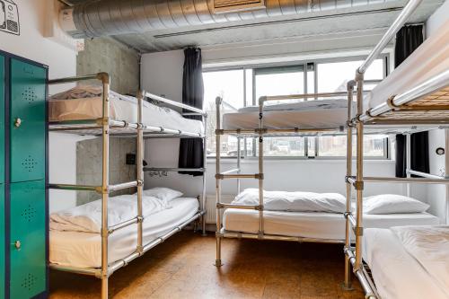 a room with three bunk beds and a window at ClinkMama in Amsterdam