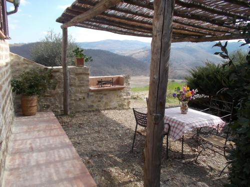 a table and chairs sitting under a wooden pergola at Agriturismo Materno in Radicondoli