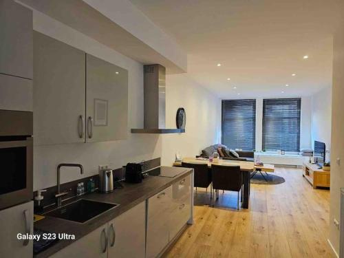 a kitchen with a table and a living room at Apartment City Center Gouda in Gouda