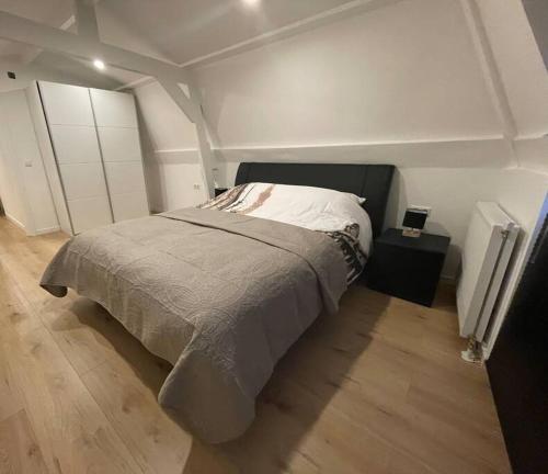 een slaapkamer met een groot bed en een houten vloer bij Apartment City Center Gouda in Gouda