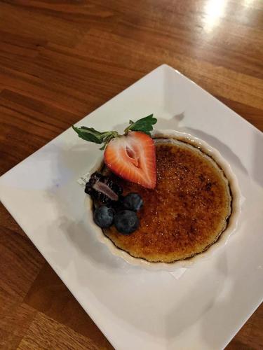 a dessert with a strawberry and blueberries on a white plate at The Long View Lodge in Long Lake